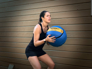 Woman getting ready to throw Variaball® variable weight medicine ball in a workout
